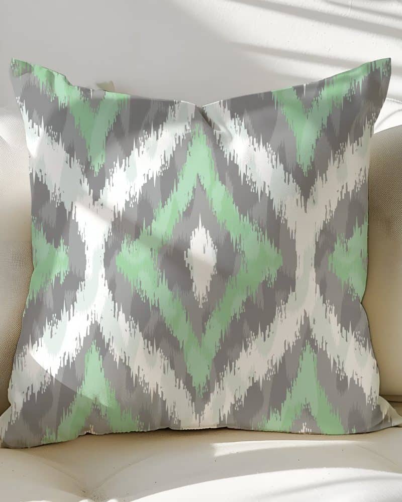 Decorative throw pillow with a green and gray ikat pattern.