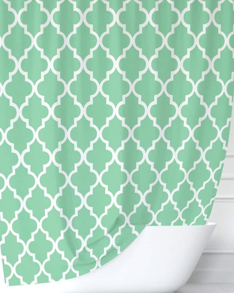 Mint green shower curtain with a white quatrefoil pattern.
