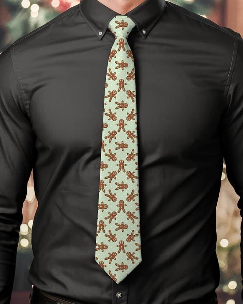 A man wearing a light green tie patterned with gingerbread men.
