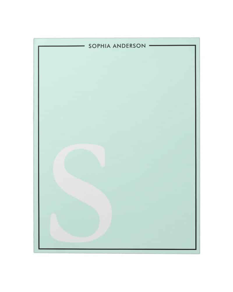 Light green notepad with a large white letter S and a name at the top.