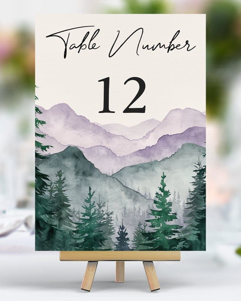 Table number twelve sign; watercolor painting of purple and green mountains with evergreen trees.