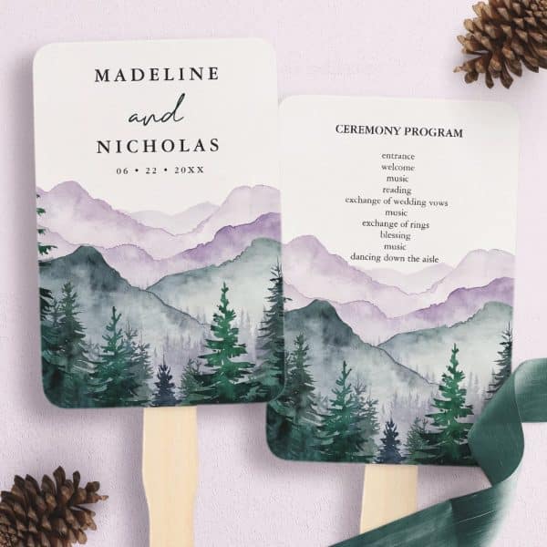 Two Wedding Ceremony Programs Shaped Like Hand Fans. Each Features A Watercolor Painting Of A Misty Mountain Range With Evergreen Trees. One Fan Displays The Couple'S Names And Wedding Date; The Other Lists The Ceremony Events.