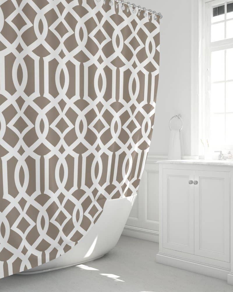 Beige and white geometric patterned shower curtain partially draped over a white bathtub.
