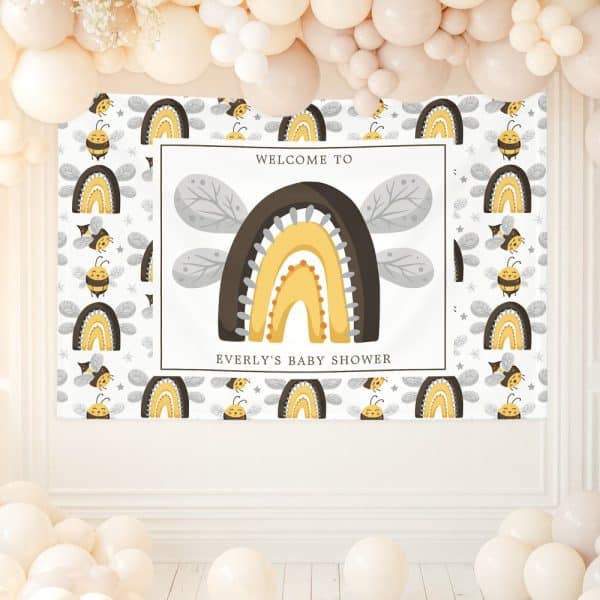 A Baby Shower Banner Featuring A Large Rainbow With Bee Wings And Small Bees And Rainbows Repeating On A White Background. The Banner Also Includes The Text Welcome To Everly'S Baby Shower.