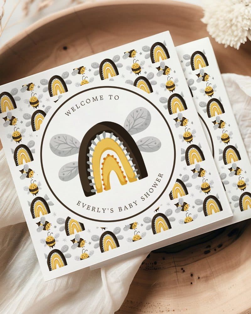 Baby shower invitation featuring a stylized rainbow and bees.