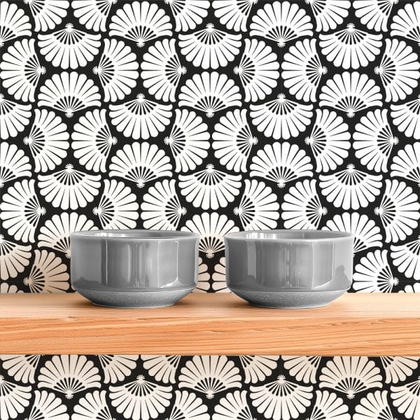 Two Gray Bowls Sit On A Light Wood Shelf Against A Black And White Patterned Wall.