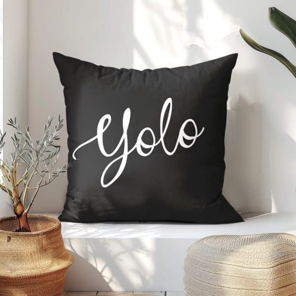 Black Pillow With The Word Yolo In White Script.