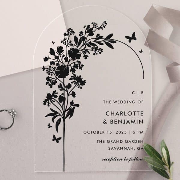 Clear Acrylic Wedding Invitation With Black Floral Design And Wedding Details.