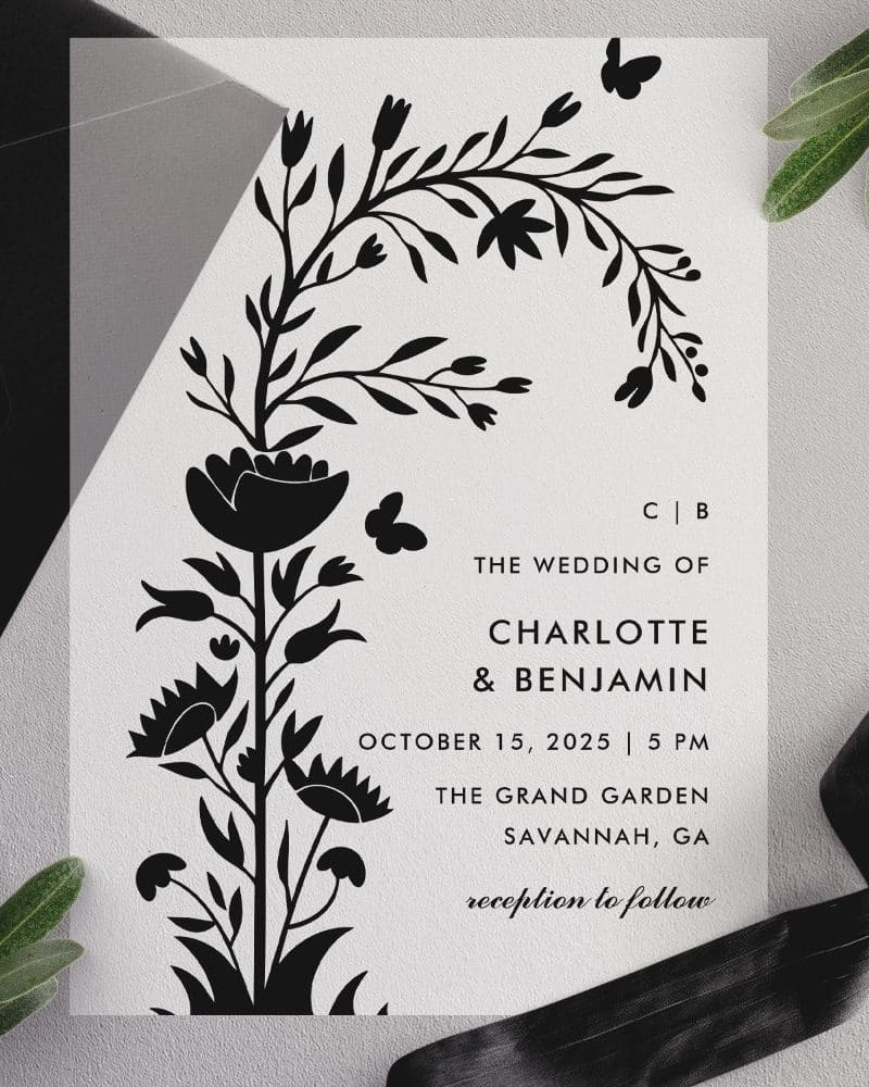 Wedding invitation with black floral illustration.