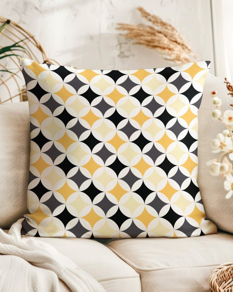 Decorative pillow with a geometric pattern in yellow, black, and gray.