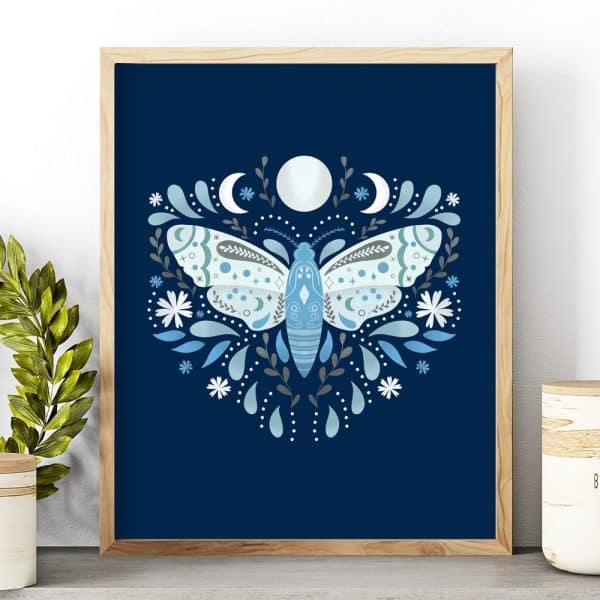 Framed Illustration Of A Light Blue Moth Centered On A Dark Blue Background, Surrounded By Floral Elements And Crescent Moons.