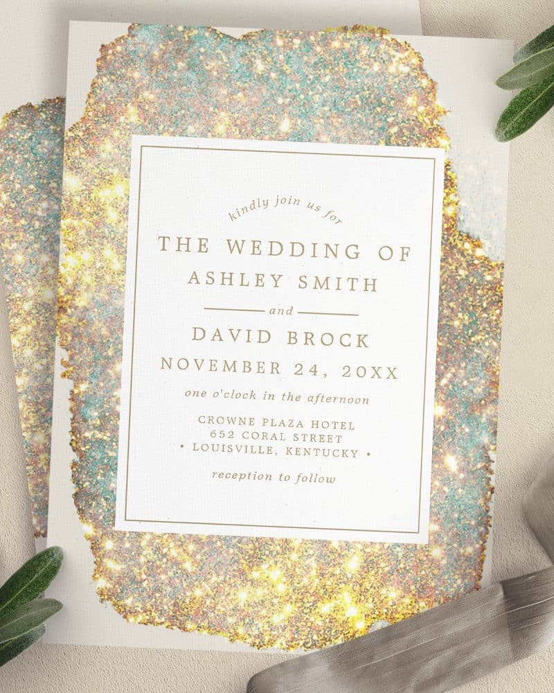 Wedding invitation for Ashley Smith and David Brock, November 24, at the Crowne Plaza Hotel in Louisville, Kentucky. The invitation features a gold and teal sparkly design.