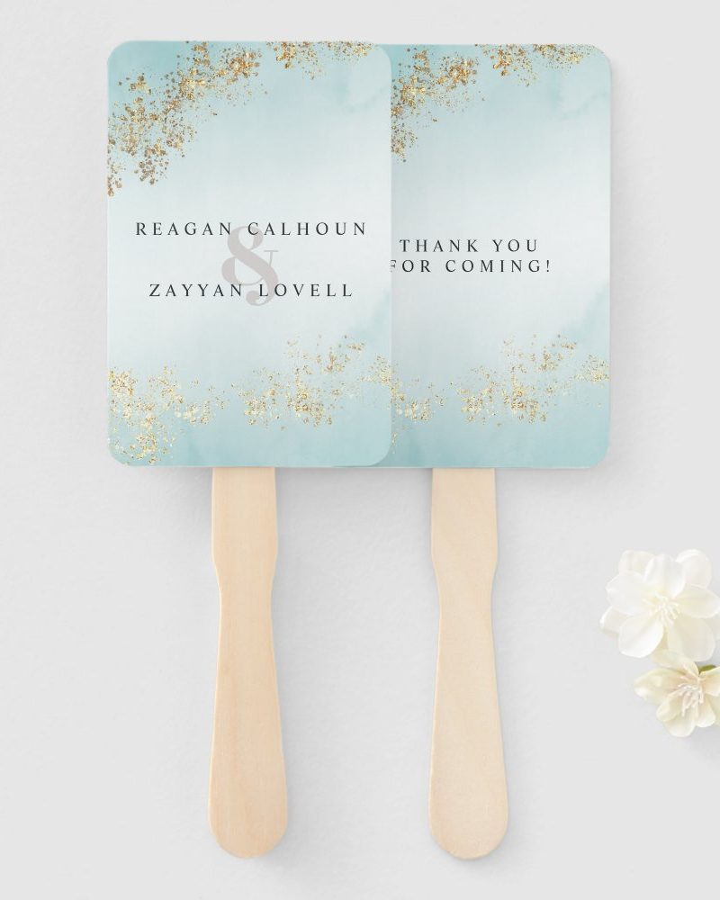 Two light blue wedding hand fans with gold glitter accents. One fan says the couple's names and the other says "Thank You for Coming!"