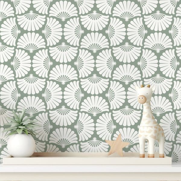 Sage Green Wallpaper With A Repeating Pattern Of White Stylized Fans. A Small Plant And A Giraffe Toy Sit On A Shelf In Front.
