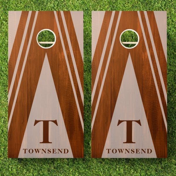 Pair Of Brown Wooden Cornhole Boards With A Beige Triangle Design, White Stripes, And The Initial T And Last Name Townsend.