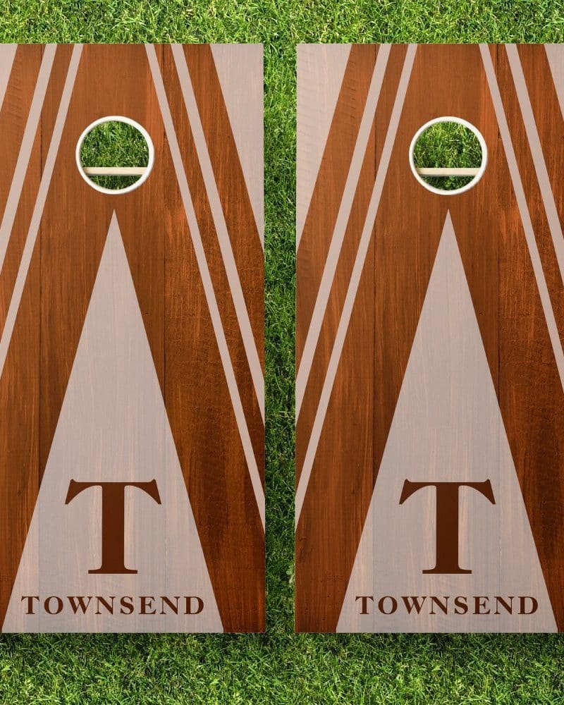 Pair of brown wooden cornhole boards with a beige triangle design, white stripes, and the initial T and last name Townsend.