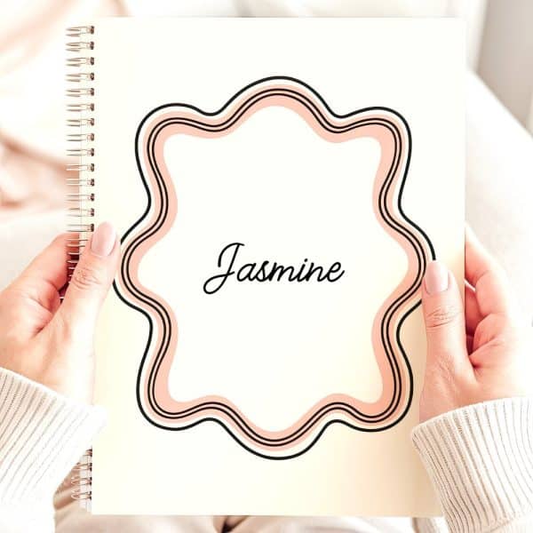 Two Hands Hold A Spiral Notebook Featuring The Name Jasmine Within A Decorative, Peach-Colored Frame.