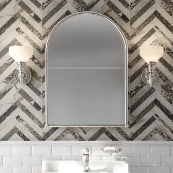 Arched Bathroom Mirror Flanked By Wall-Mounted Lights, Above A White Subway Tile Backsplash.