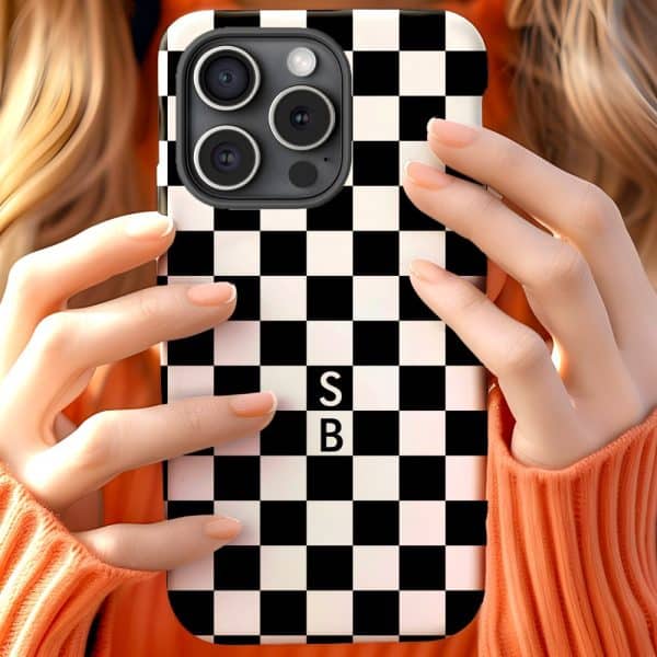 Hands Holding A Phone In A Black And White Checkered Phone Case. The Initials Sb Are In The Center.