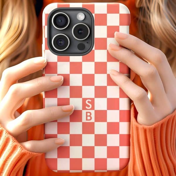 Close-Up Of Hands Holding A Coral And White Checkered Phone Case With The Initials Sb.