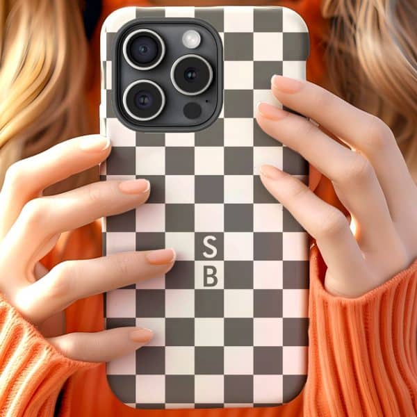 Close-Up Of Hands Holding A Phone In A Black And White Checkered Case With The Initials Sb.