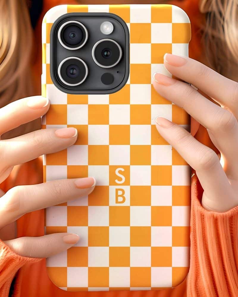 Hands holding an orange and white checkered phone case.