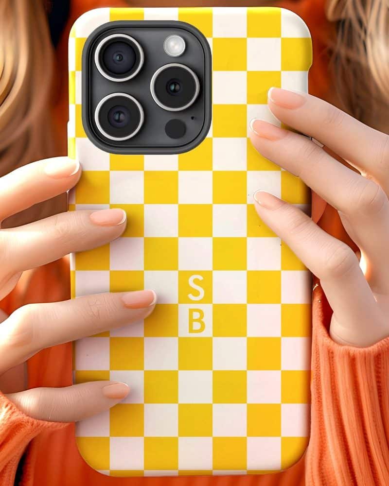 Close-up of hands holding a yellow and white checkered iPhone case.