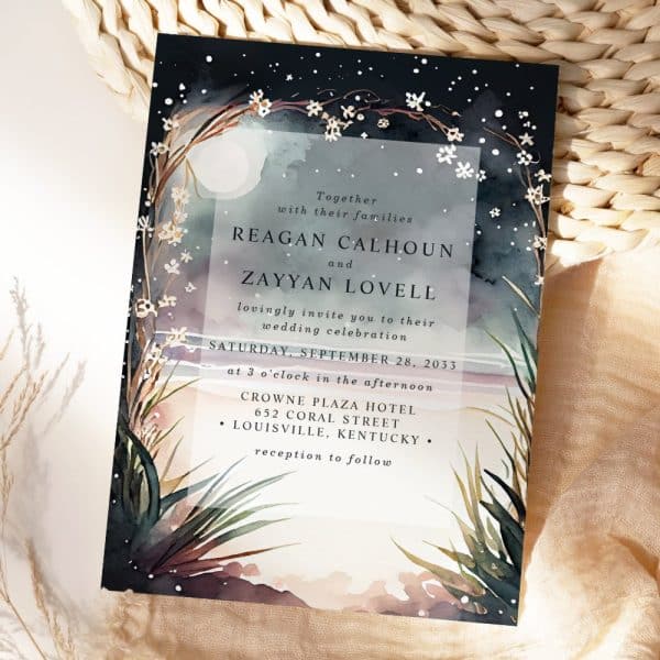 Wedding Invitation With A Dark Watercolor Background Featuring A Moon, Stars, And Floral Elements. The Names Reagan Calhoun And Zayyan Lovell Are Prominently Displayed.