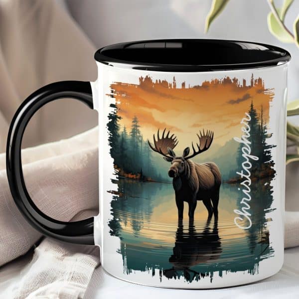 Black-Handled Mug With A Personalized Name And Illustration Of A Moose Standing In A Lake At Sunset.