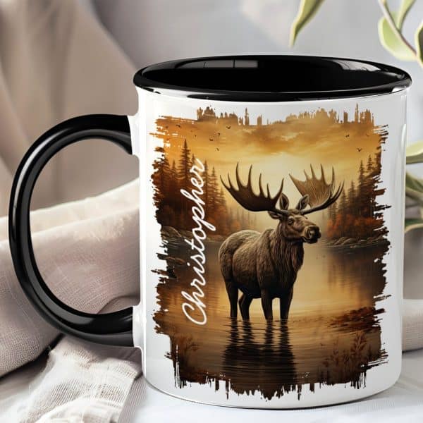 Black-Handled Mug With A Personalized Name And Image Of A Moose Standing In A Lake At Sunset.