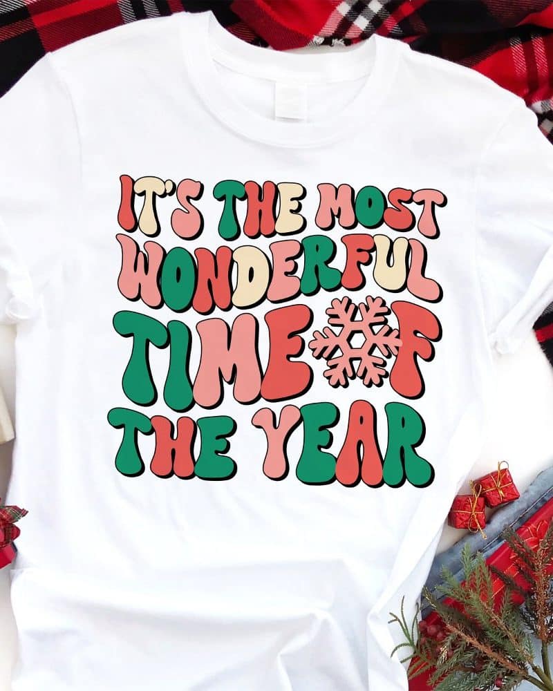 White t-shirt with the text Its the most wonderful time of the year in retro style lettering and a snowflake.