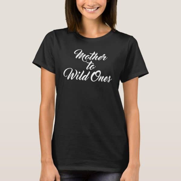 Woman Wearing A Black T-Shirt That Says Mother To Wild Ones In White Cursive Lettering.