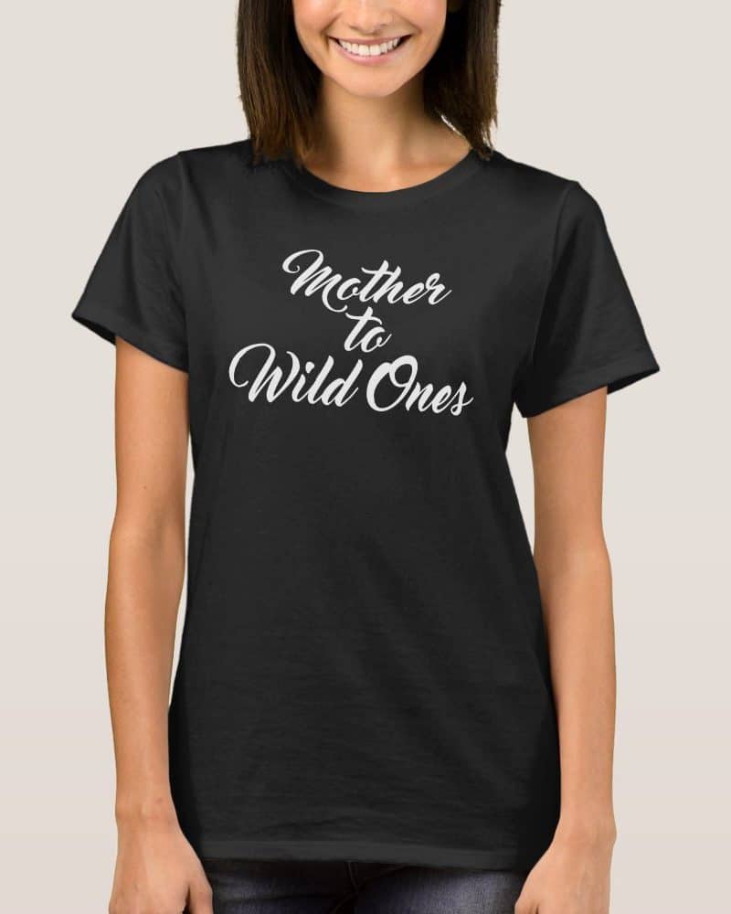 Woman wearing a black t-shirt that says Mother to Wild Ones in white cursive lettering.