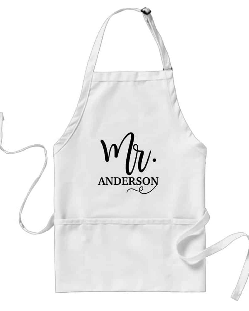 White apron with black script lettering that says Mr. Anderson.