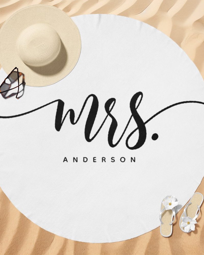 White round beach towel with the word Mrs. and the last name Anderson in elegant black script.