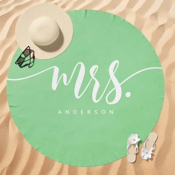A Light Green Round Beach Towel With Mrs. Anderson Written In A Stylized White Script.