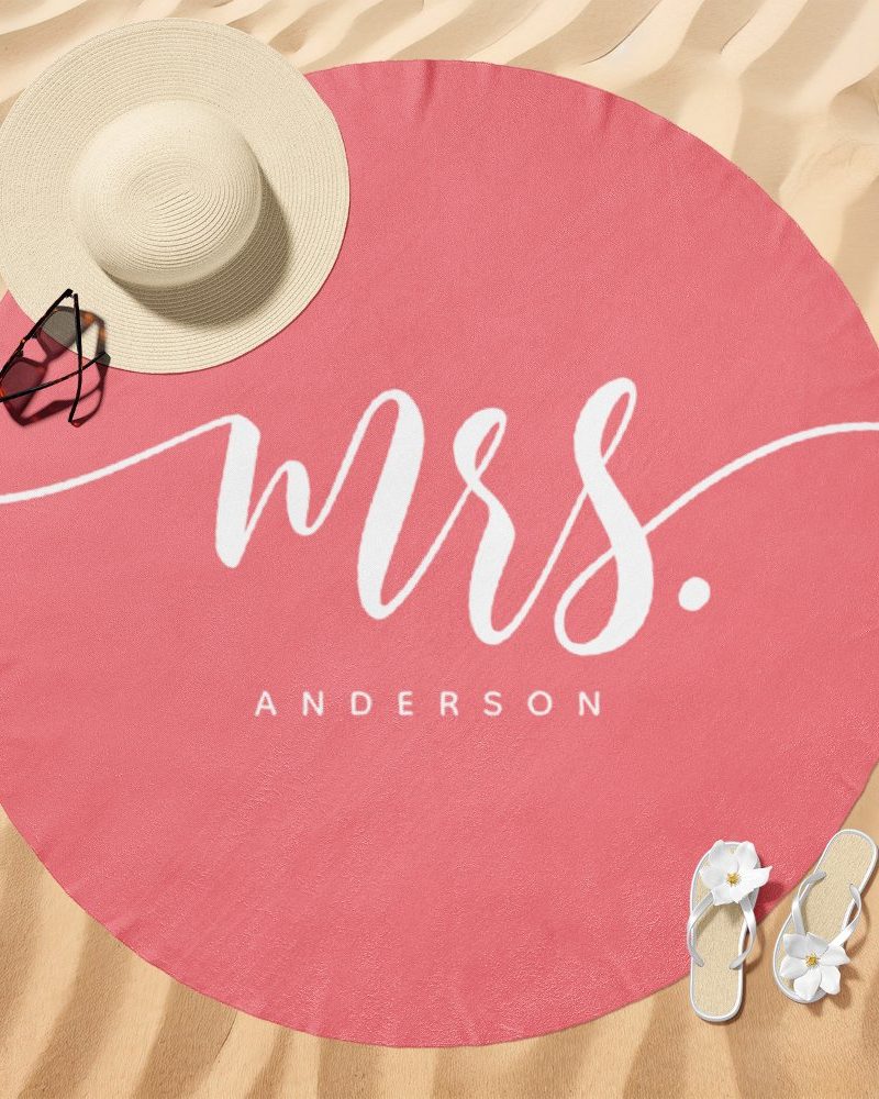 Pink round beach towel with Mrs. Anderson in white script.