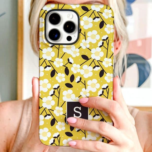 A Yellow Iphone Case With A White Floral Pattern And A Black Initial S.