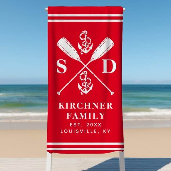 Red Beach Towel With A White Family Name, Initials, And Nautical Design.