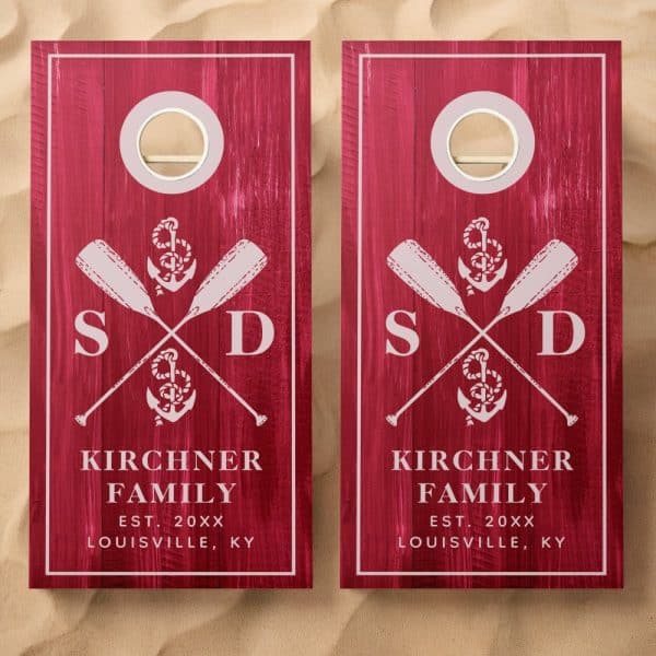 Pair Of Maroon Cornhole Boards With A Nautical Theme, Featuring Crossed Oars, An Anchor, And Family Initials.