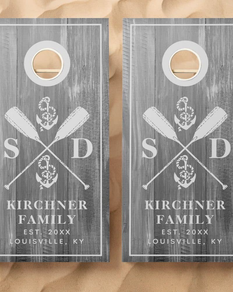 Pair of gray wooden cornhole boards with a nautical theme. Each board features crossed oars, an anchor, and the Kirchner family name and location.