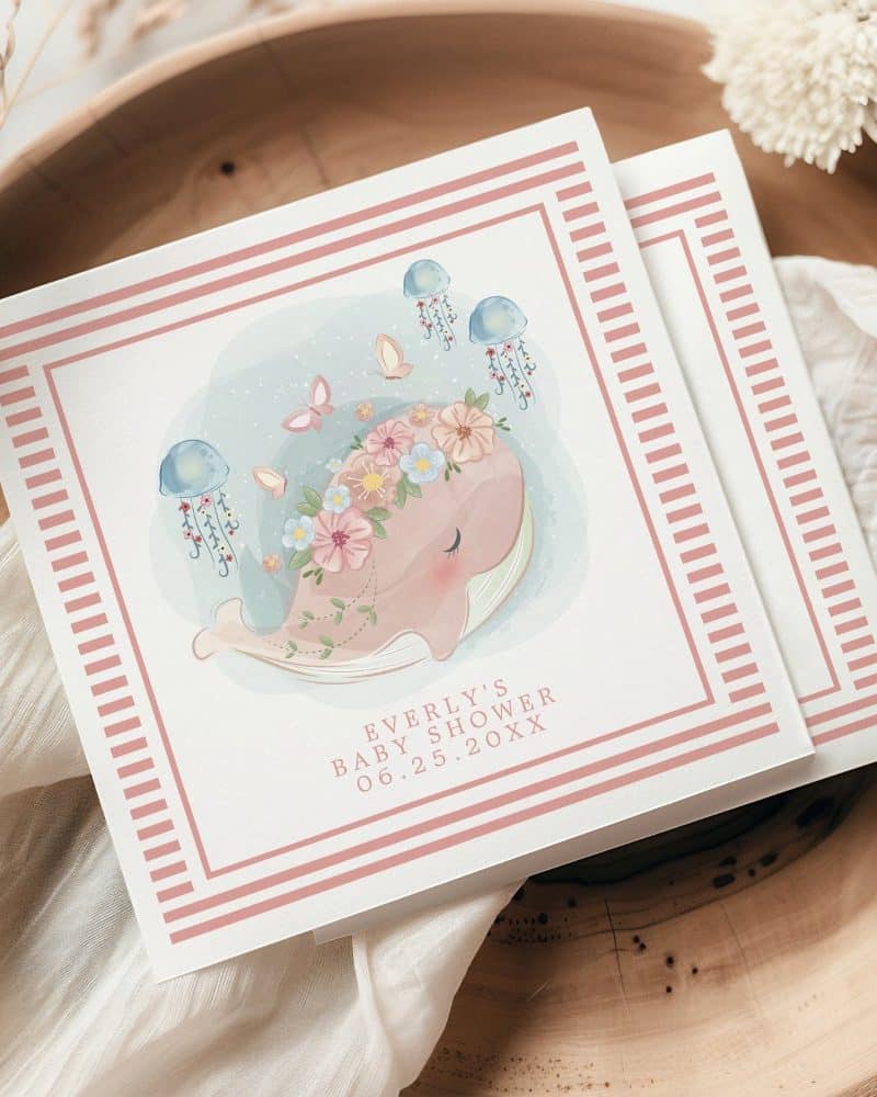 Baby shower invitation featuring a floral whale with jellyfish and butterflies.