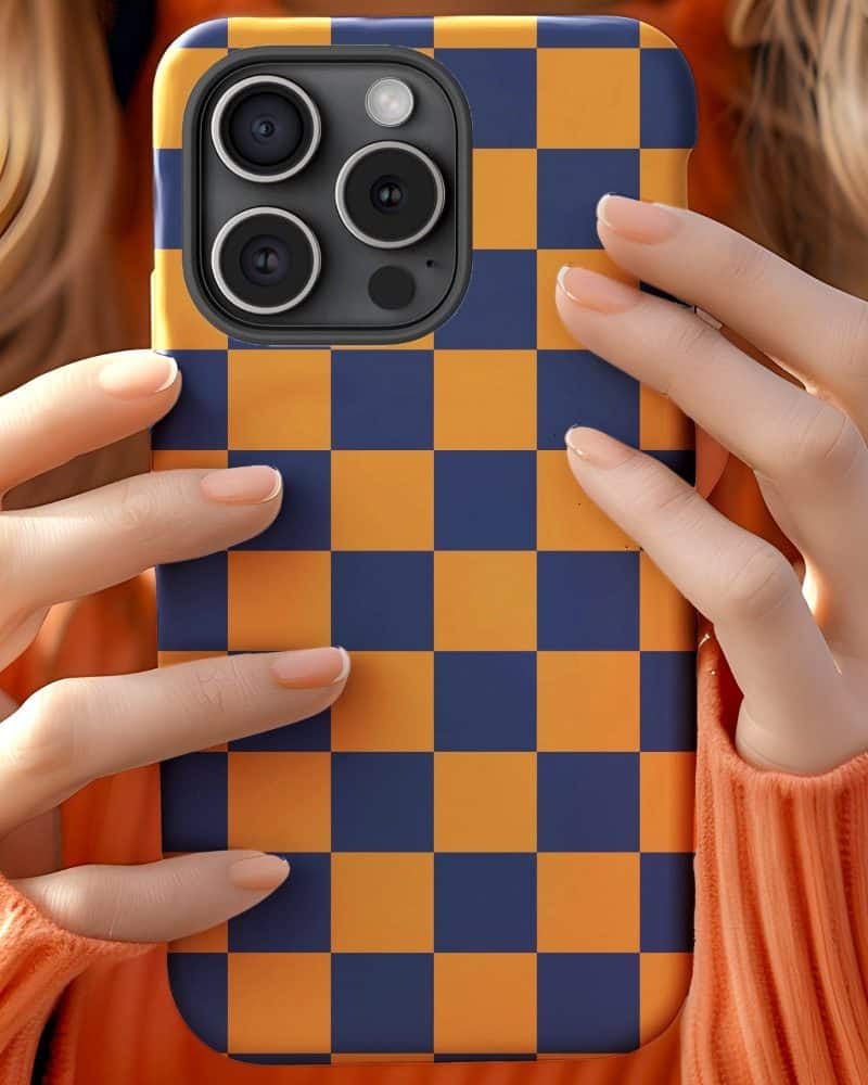 Hands holding a phone in a blue and orange checkered case.