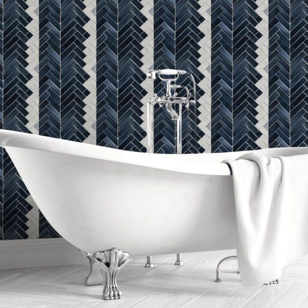 White Clawfoot Bathtub In Front Of A Dark Blue And White Herringbone Tile Wall.