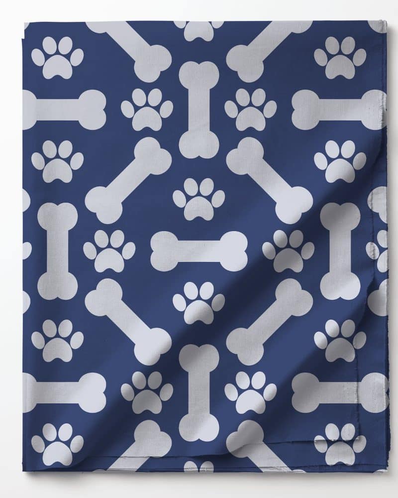 Blue fabric with a repeating pattern of white paw prints and bones.