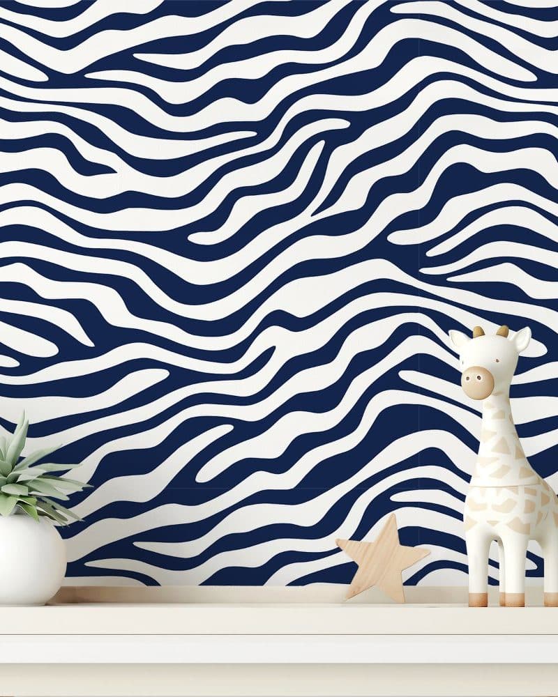 Navy blue and white zebra striped wallpaper with a small giraffe figurine and succulent plant on a shelf.