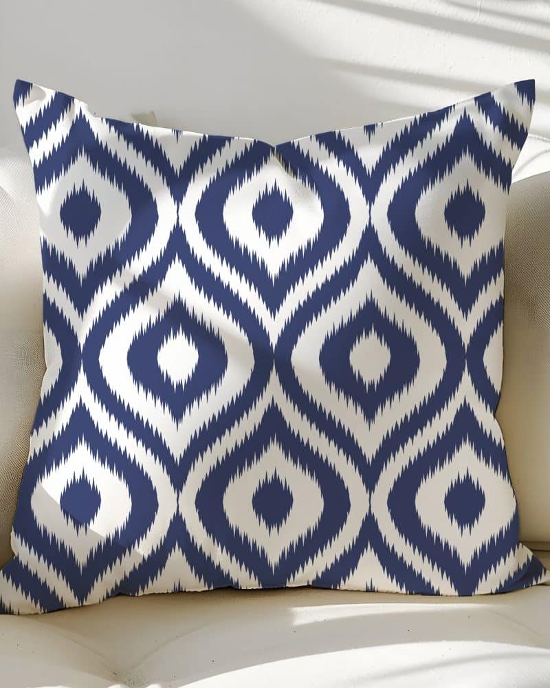 Navy blue and white patterned throw pillow with an ikat design.
