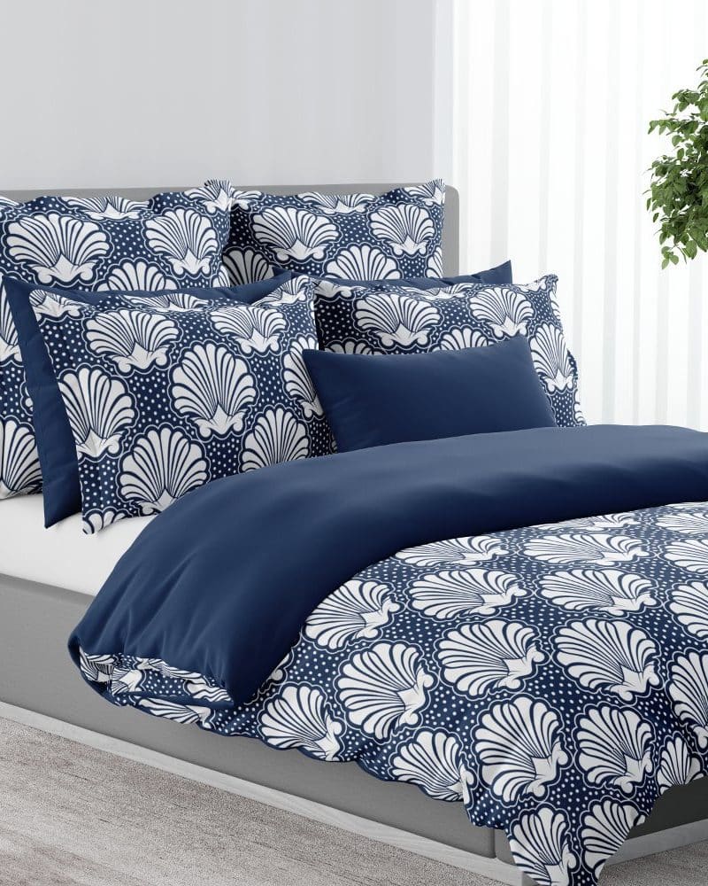 Navy blue duvet cover and shams with a white seashell pattern.