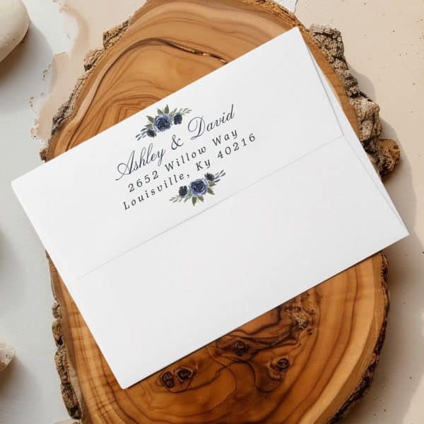 A White Envelope With A Return Address Featuring Ashley &Amp; David'S Name And Louisville, Kentucky Address, Decorated With A Floral Design.