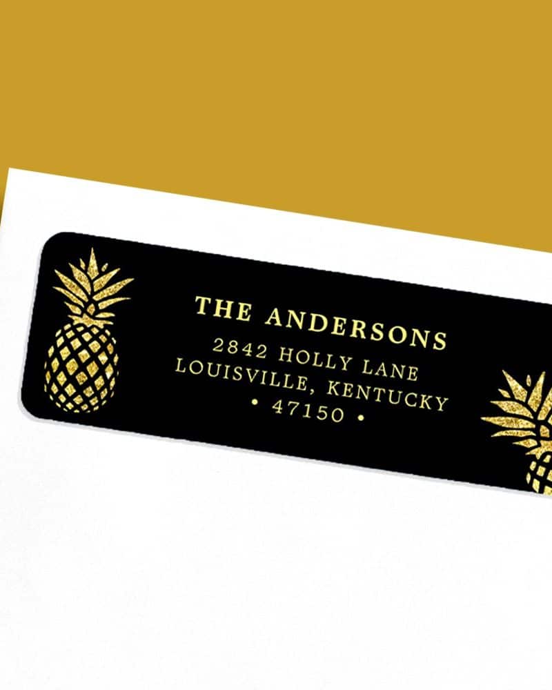 Black return address label with gold glitter pineapples and the Andersons' address in gold lettering.